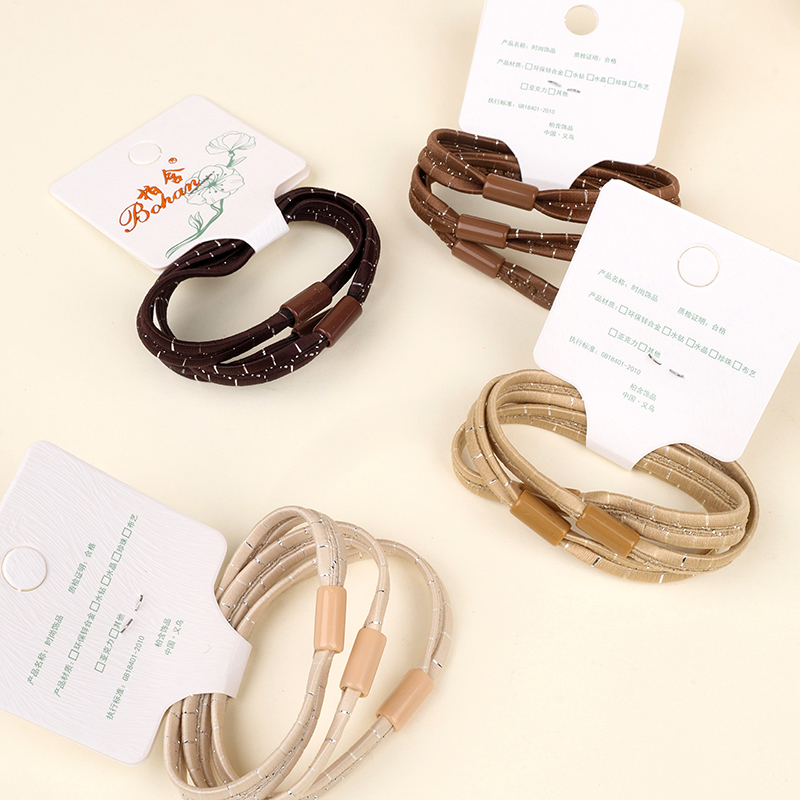 Three cream-colored bright silk flat rubber bands